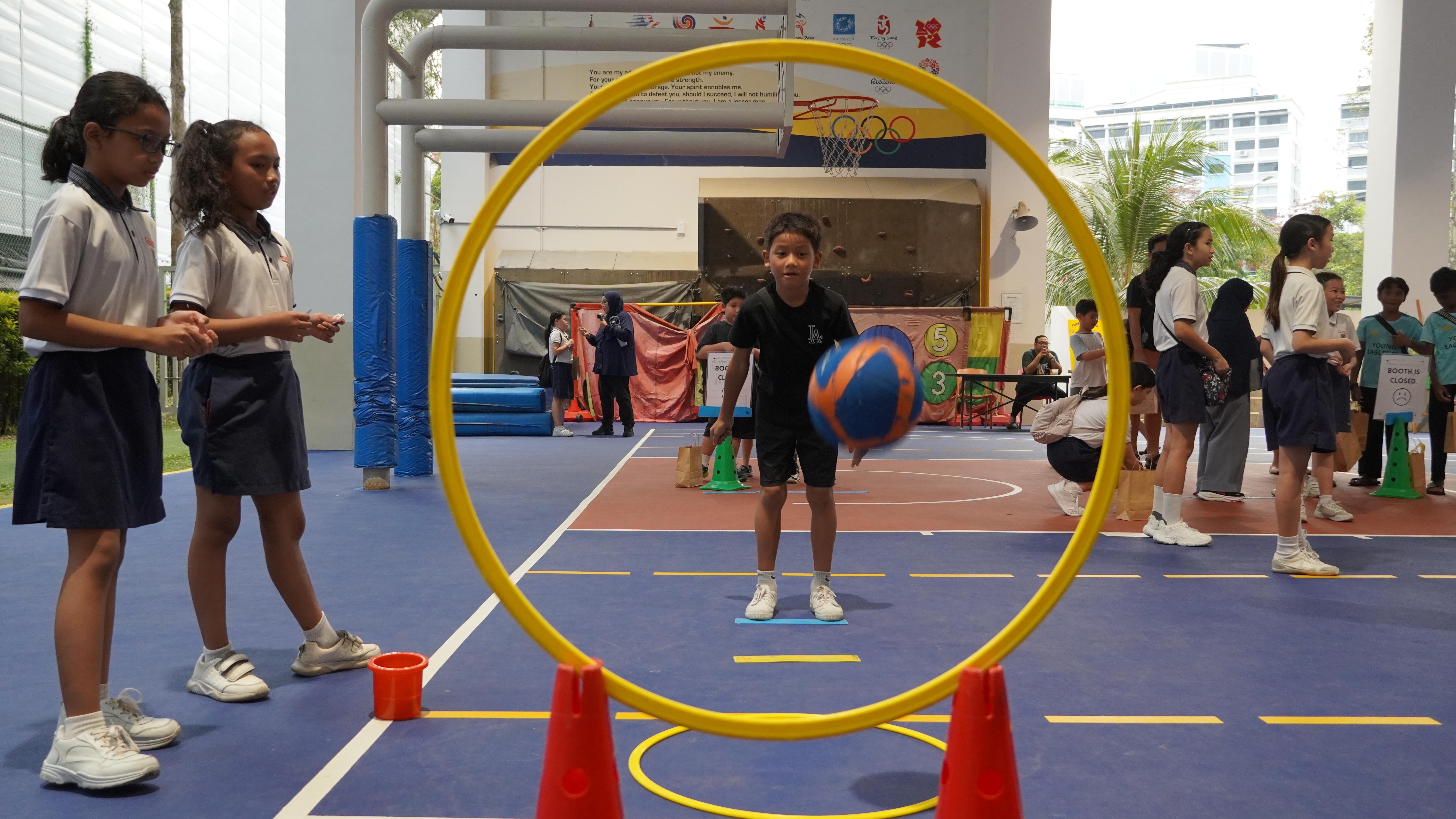 Right through the hoop! Eyes on the target as our student takes on this fun ball challenge.